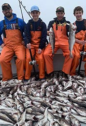 4 dads and kids on boat with large amount of caught cod fish